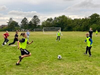 Kinder spielen Fußball auf dem Feld.