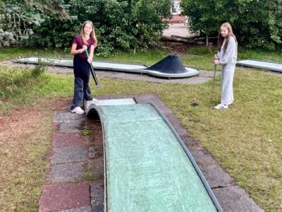 Zwei Mädchen beim Minigolfspielen.