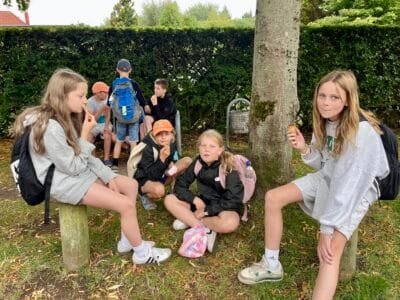 Kinder sitzen im Freien zusammen.