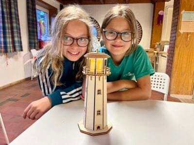 Zwei Kinder mit einem Leuchtturm.