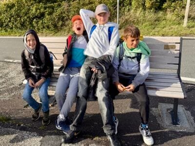 Vier Kinder sitzen auf einer Bank.