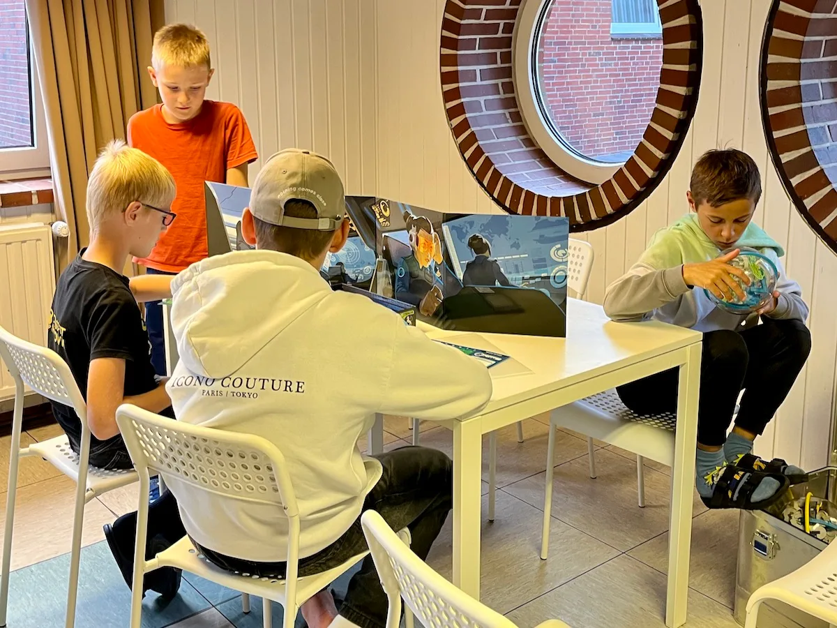 Kinder spielen an einem Tisch.