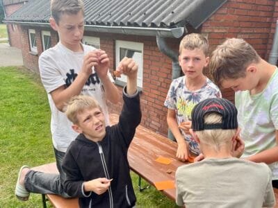 Kinder spielen draußen am Tisch.