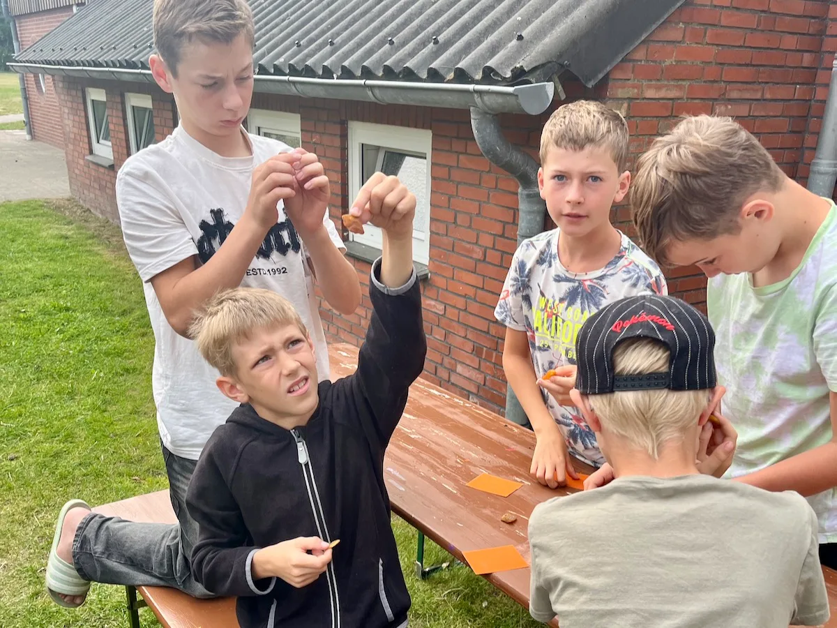 Kinder spielen draußen am Tisch.