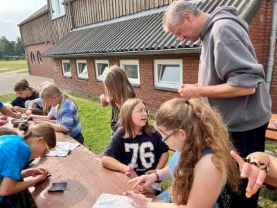 Kinder basteln im Freien.