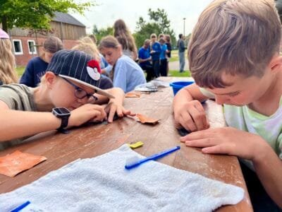 Kinder arbeiten an einem Tisch.