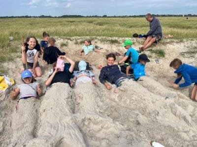 Kinder spielen im Sand am Strand.