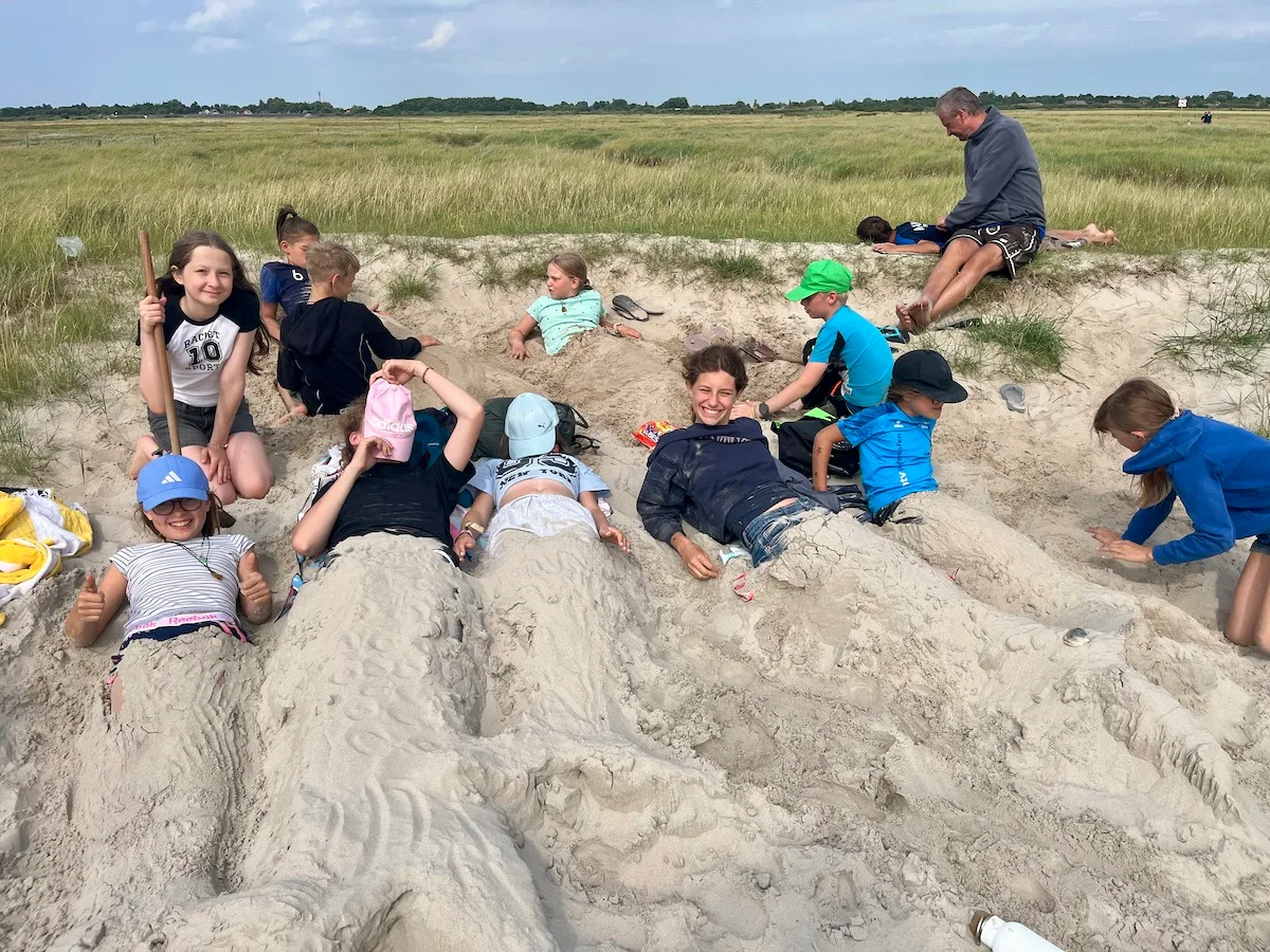 Kinder spielen im Sand am Strand.