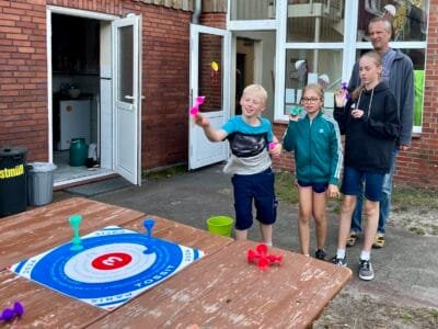 Kinder spielen ein Zielspiel draußen.