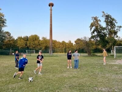 Kinder spielen Fußball im Freien.