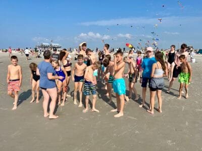 Menschen am Strand mit Drachen.