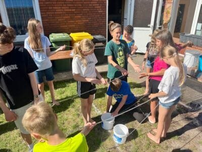 Kinder spielen im Freien mit Seilen.