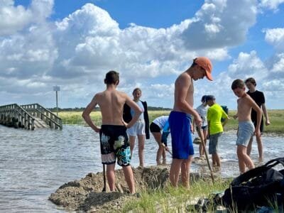 Kinder spielen am Wasser bei Sonne.