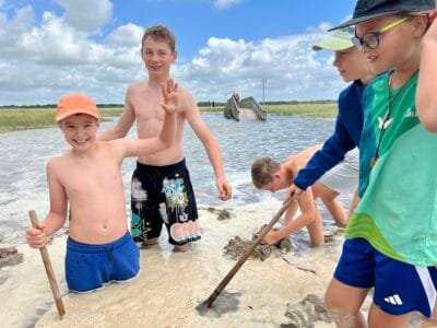 Kinder spielen im flachen Wasser.