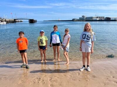 Fünf Kinder am Strand im Wasser