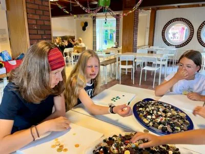 Kinder spielen mit Knöpfen am Tisch