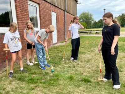 Kinder spielen mit Schlägern im Freien