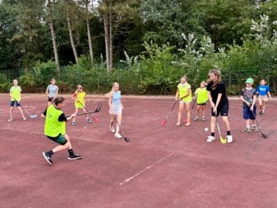 Kinder spielen Hockey im Freien