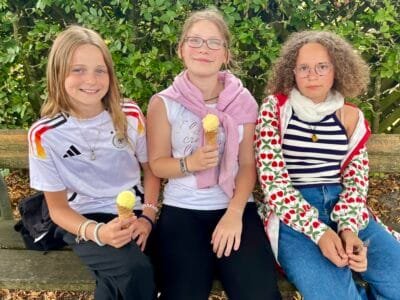 Drei Mädchen mit Eis auf einer Bank