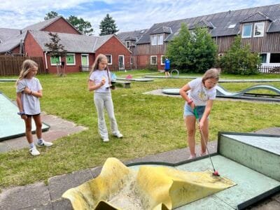 Kinder spielen Minigolf im Freien