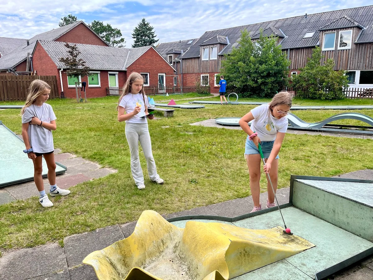 Kinder spielen Minigolf im Freien