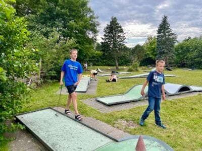 Kinder spielen Minigolf im Freien