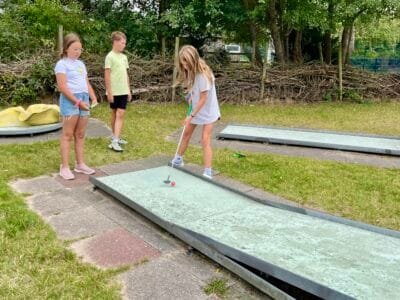 Kinder spielen Minigolf im Freien