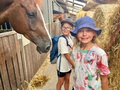 Kinder im Stall mit Pferden