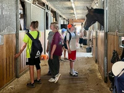 Kinder im Stall mit Pferden