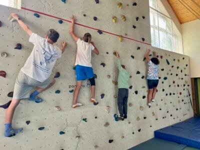Vier Personen klettern an Wand.