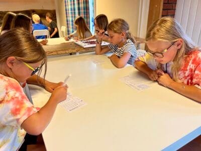 Kinder machen Aufgaben am Tisch.