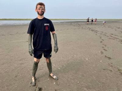 Junge mit Schlamm am Strand