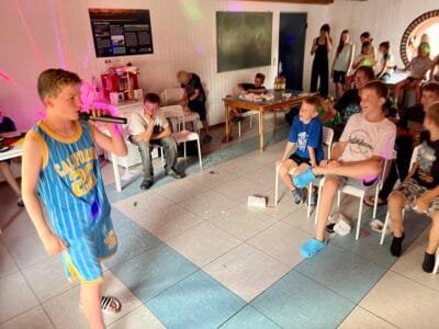 Junge singt vor Publikum bei Party.
