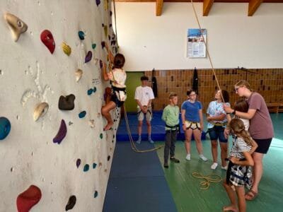 Kinder klettern an einer Wand.