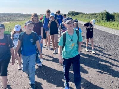 Kinder gehen auf einem Weg.