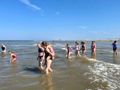 Mädchen spielen im Wasser am Strand.