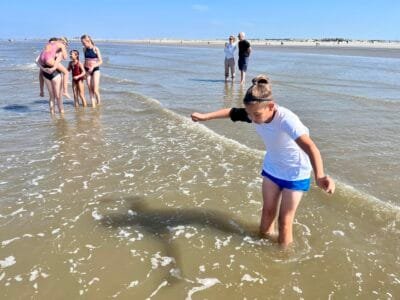 Kinder spielen am Strand im Wasser