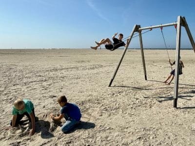 Kinder spielen am Strand mit Sand.