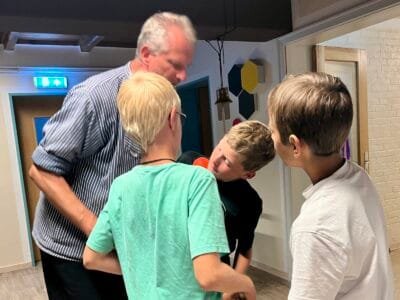 Vier Kinder und ein Erwachsener interagieren.