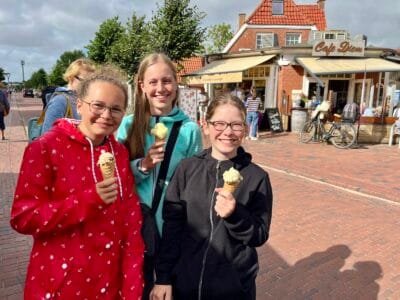 Drei Mädchen mit Eiscreme lächeln.