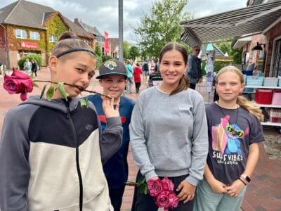 Vier Kinder mit Blumen in der Stadt