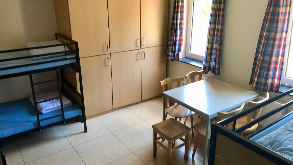 Mehrbettzimmer mit Schrank und Tisch